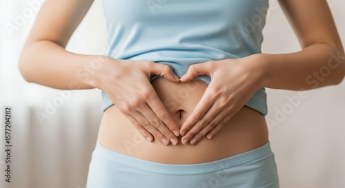 Wallpaper Mural Woman's Hands Forming Heart Shape on Stomach, Promoting Gut Health and Digestive Wellness Torontodigital.ca