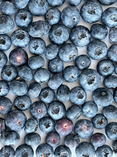 Fototapeta Close-up of fresh ripe blueberries scattered on a light surface