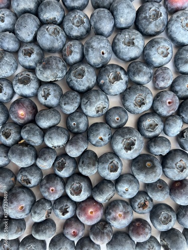 Fotografie Close-up of fresh ripe blueberries scattered on a light surface