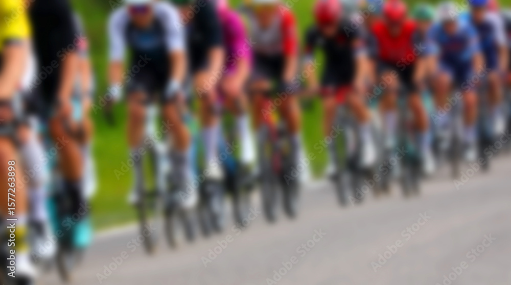 Obraz premium Intentionally blurred group of cyclists riding racing bikes during competitive road race