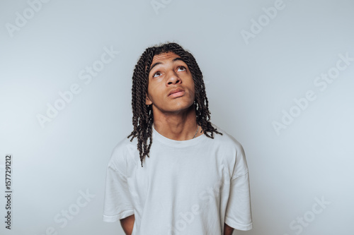 Billede på lærred young man gazes upward with a contemplative expression, evoking curiosity and in