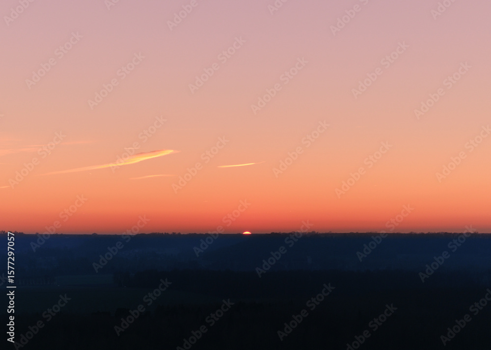 Fototapeta premium Golden Hour Glow: Fiery Sun on the Horizon Landscape