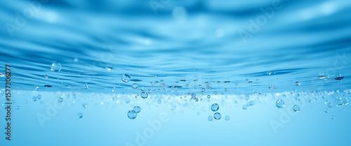 Beautiful closeup reveals the underwater world with clear ripples and floating bubbles in light blue liquid, creating a refreshing aquatic scene.