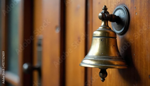 A vintage brass bell hanging on a wooden door, ready to be rung to announce an arrival or request service Perfect for hospitality, vintage, and hotel themed projects , pull bell, inn