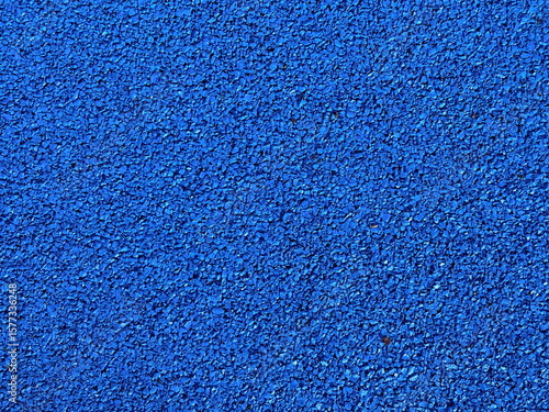 Vibrant blue rubber granule road surface in close-up, gritty texture perfect for sports track backgrounds