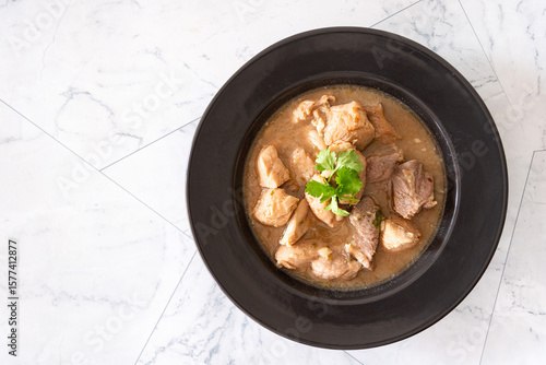 Top view delicious stewed pork served on a plate, showcasing juicy, tender meat with crispy golden-brown skin.