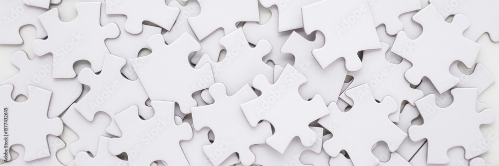 Different many white puzzle pieces background. Wide banner. Closeup. Top down view. Different many white puzzle pieces background. Wide banner. Closeup. Top down view.