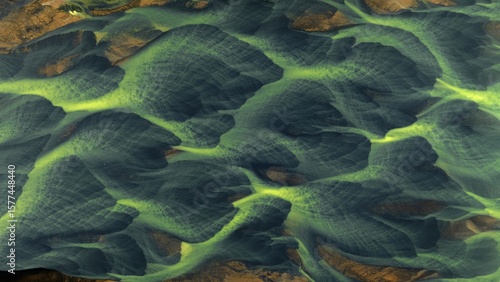Aerial view of braided river channels carve through the landscape, creating a mesmerizing pattern of green and gold, Landmannalaugar, Iceland.