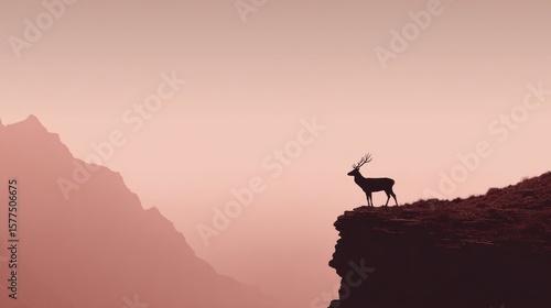 Silhouetted deer on a mountain peak at dawn