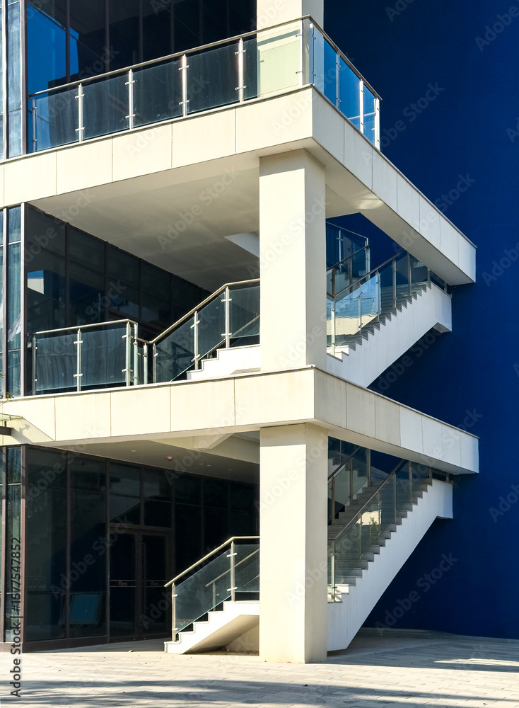 Fototapeta premium Contemporary Architectural Design Featuring Stacked Staircase Against Vibrant Blue Wall