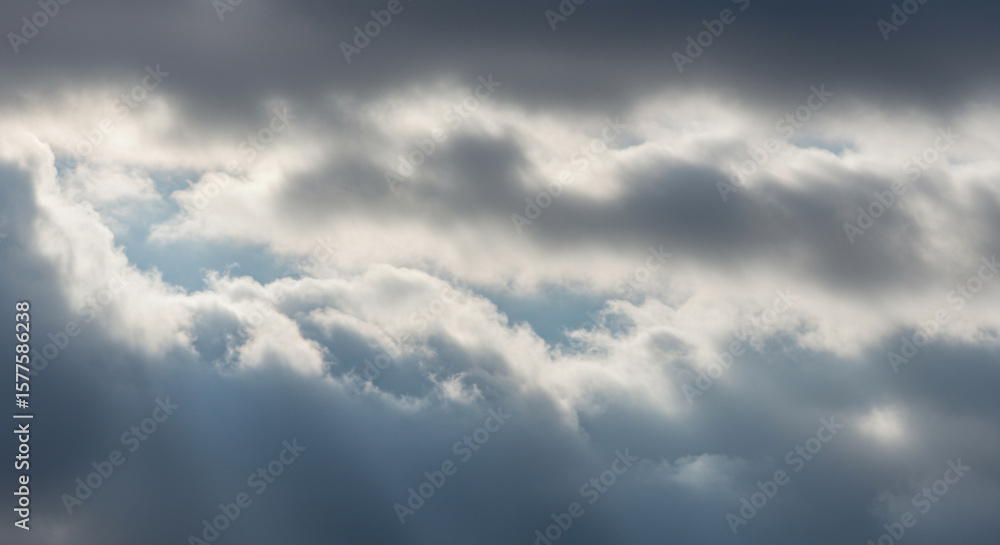 Obraz premium A close-up view of dramatic, textured clouds with patches of sunlight.