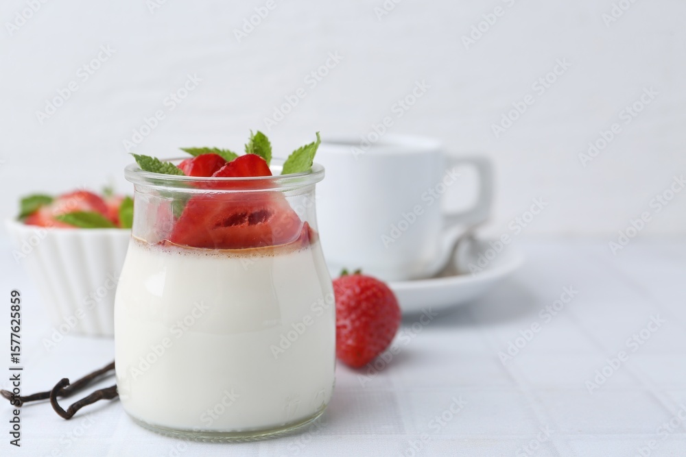Tasty panna cotta with caramel, strawberries, mint, vanilla pods and coffee on white tiled table, closeup. Space for text Tasty panna cotta with caramel, strawberries, mint, vanilla pods and coffee on white tiled table, closeup. Space for text