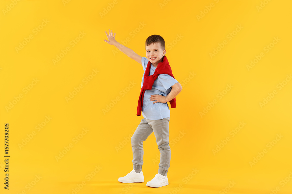 Happy little boy dancing on orange background Happy little boy dancing on orange background