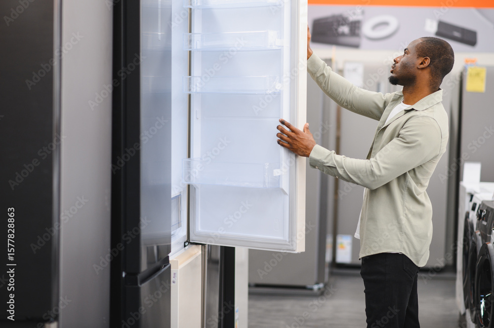 Customer choosing refrigerator in appliance store or shopping mall Customer choosing refrigerator in appliance store or shopping mall