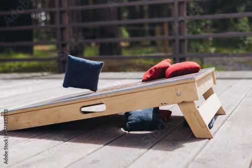 Fototapeta Cornhole game set, process of throwing bean bags, female girl tossing bean sacks
