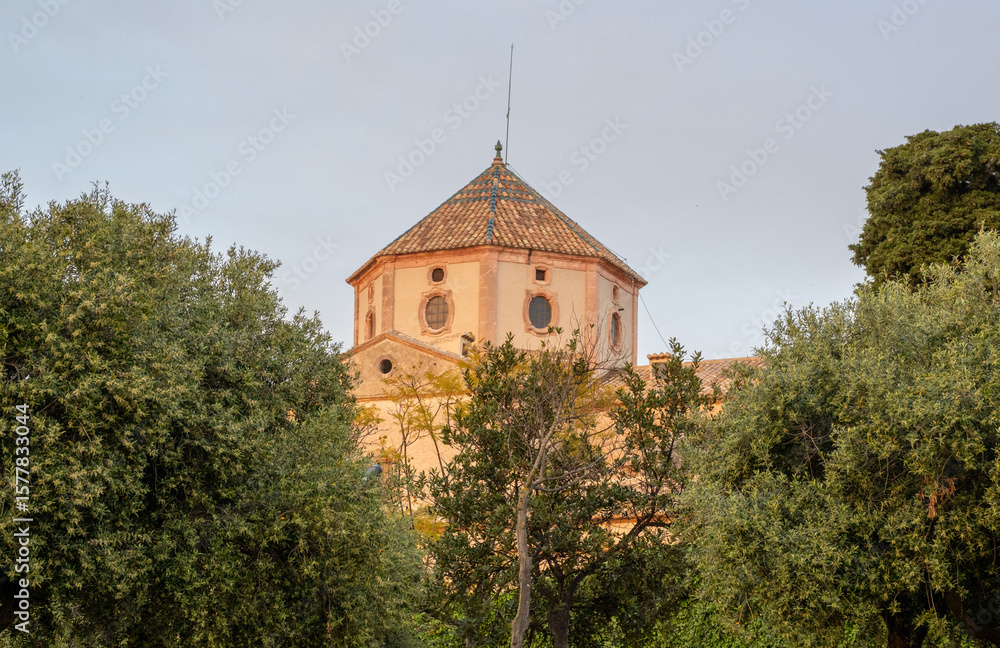 Naklejka premium Gothic-style Sant Martí Parish and clock tower in Altafulla, Catalonia, rising over the charming historic town. A Spanish architectural gem.