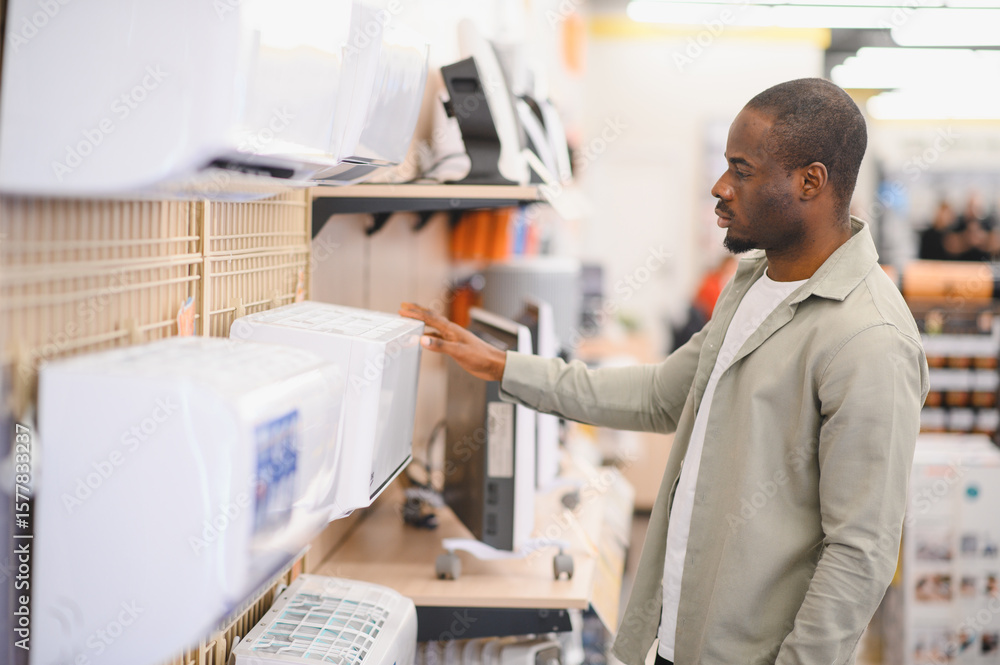 Customer choosing air conditioner in electronics store. Customer choosing air conditioner in electronics store.