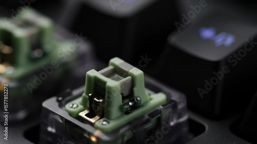 Ultra-close macro of a mechanical keyboard switch actuating. The moving parts, spring tension, and plastic guides engage in slow motion as the keypress triggers a subtle light pulse.



