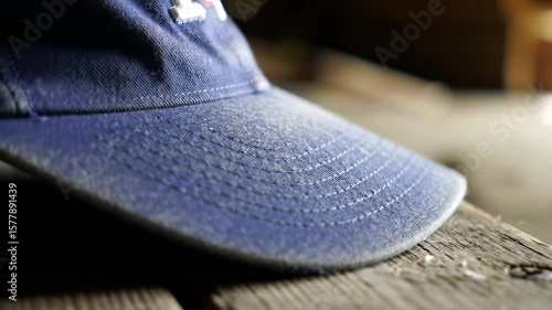 Close-up of a dusty blue baseball cap on a weathered wooden surface