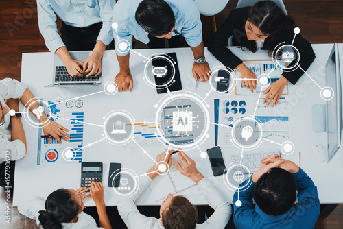 Behang A dynamic business meeting showcasing professionals collaborating over data analysis with laptops and charts, emphasizing teamwork and technology in a modern office