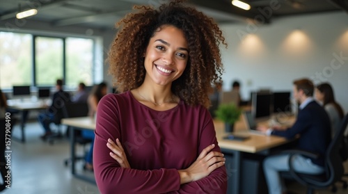 Confident Young African American Businesswoman with Curly Hair Smiling in a Modern Office Environment.