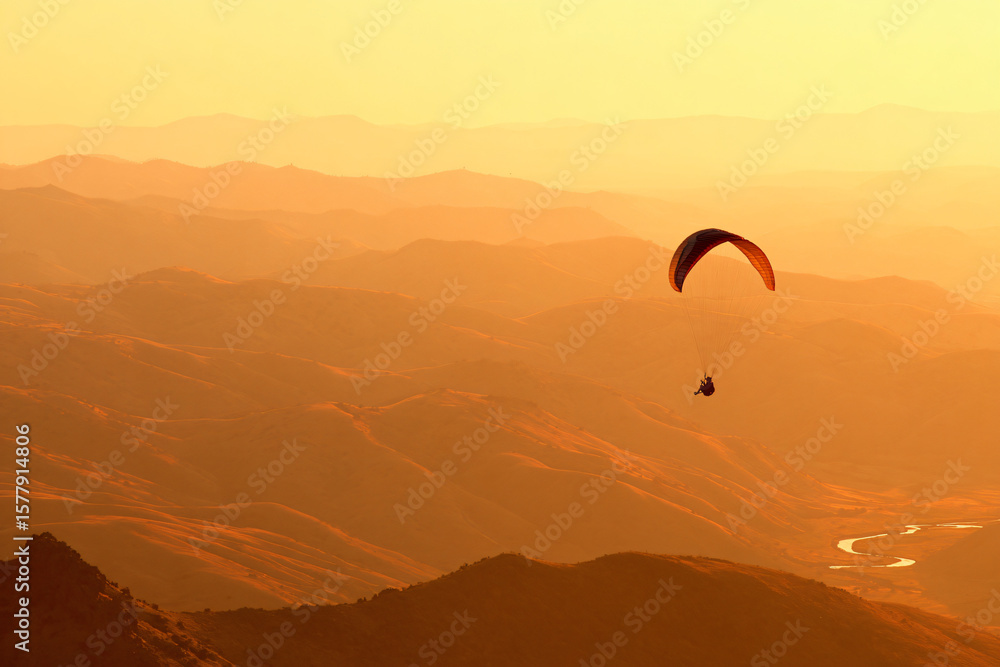 paraglider silhouetted against sunset canyon panorama, serpentine river cutting through ancient rock paraglider silhouetted against sunset canyon panorama, serpentine river cutting through ancient rock