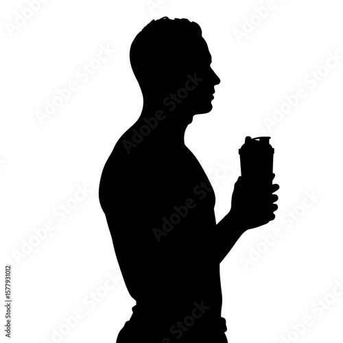 Man holding a drink while standing in silhouette 