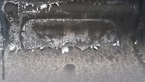 A detailed image highlighting the peeling paint and rust on the surface of a well-used barbecue grill. The textures reveal signs of wear and environmental exposure.