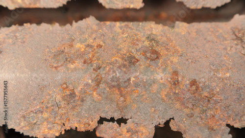 Detailed close-up image of a rusted metal surface, highlighting the texture and colors of corrosion. The decayed surface evokes a sense of age and neglect.
