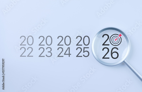 The 2026 New Year business goals concept. Magnifying glass focus year 2026 with a target icon, representing focus on business goals and objectives for the future. Marketing trend, business growth,