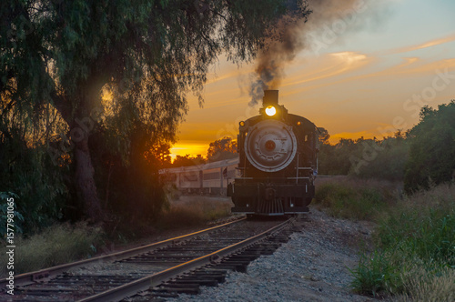 Vintage steam passenger train rounds bend at sunset