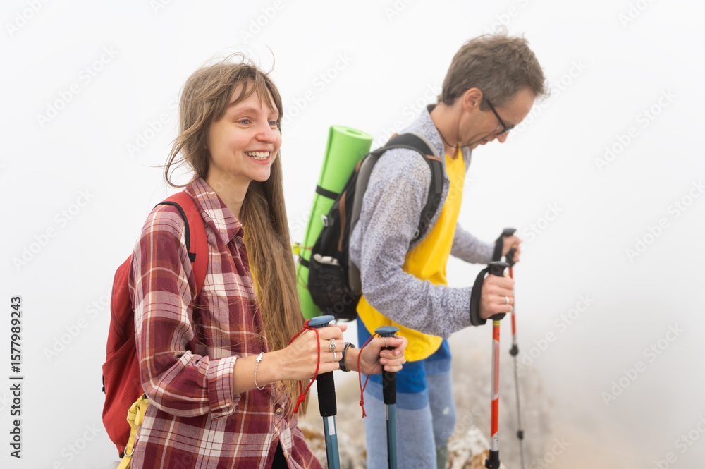 Smiling Hikers Trekking in Foggy Mountain Landscape During Morning Adventure Smiling Hikers Trekking in Foggy Mountain Landscape During Morning Adventure