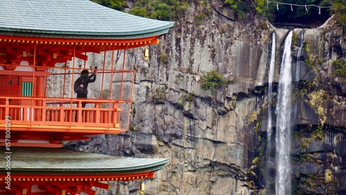 Person taking a photograph at an amazing Red pagoda and waterfall in Japan