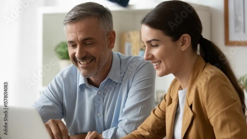 Wallpaper Mural Business colleagues smile while working together on a laptop at the office Torontodigital.ca