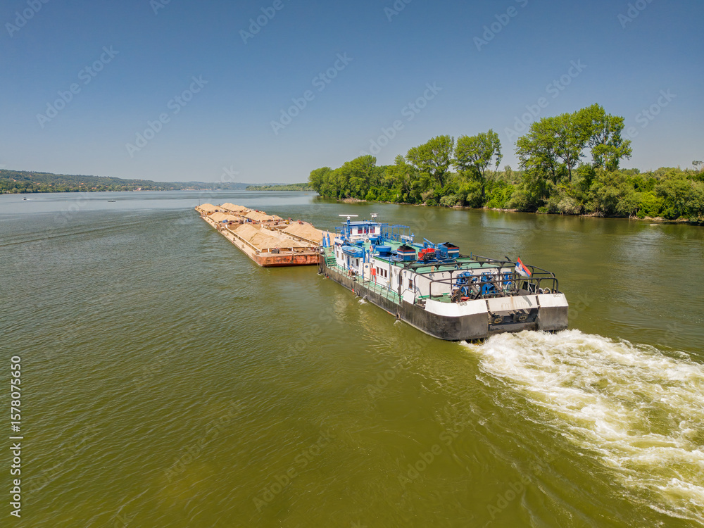 Naklejka premium Drone view of a barge navigating the Sava River in Smederevo Serbia on a clear summer day