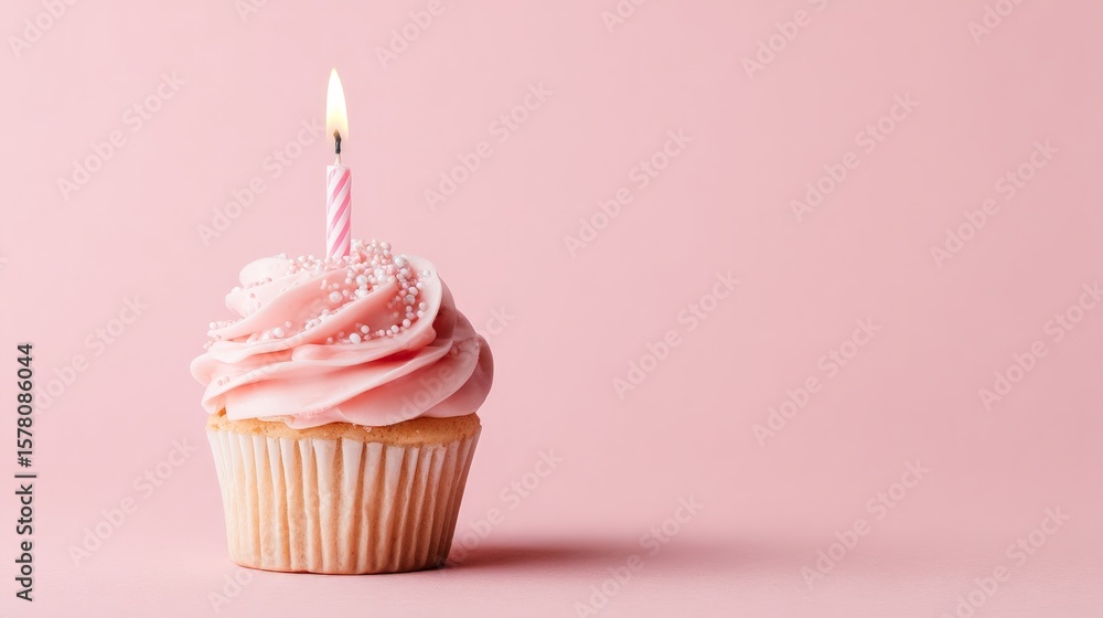 Pink Birthday Cupcake with Lit Candle on Pink Background Pink Birthday Cupcake with Lit Candle on Pink Background