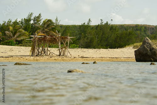 Structure on the beach with a cliff in the background