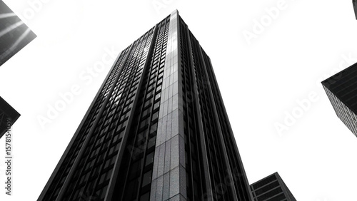 Low angle view of a tall skyscraper with many windows against a bright white sky in black and white