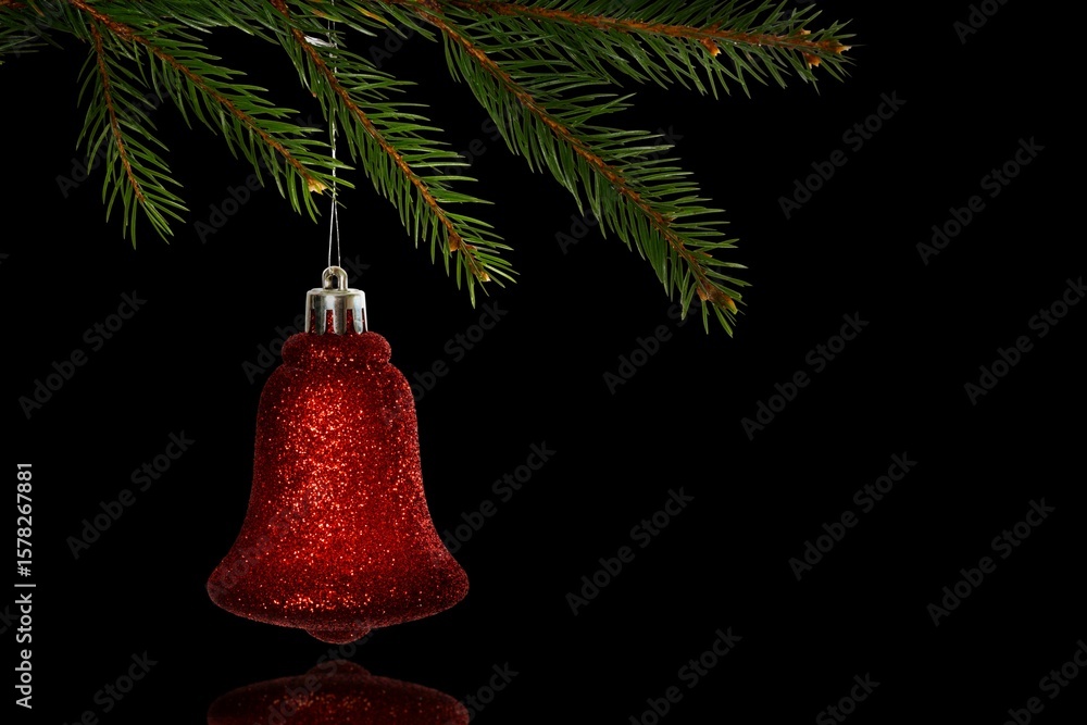 Fototapeta premium Red glitter bell ornament is hanging from pine branch in 3D with silver cap, black backdrop
