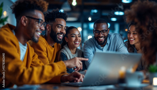 Happy colleagues collaborating on a laptop in a late night office meeting. Perfect for team projects, brainstorming sessions, coworking spaces.