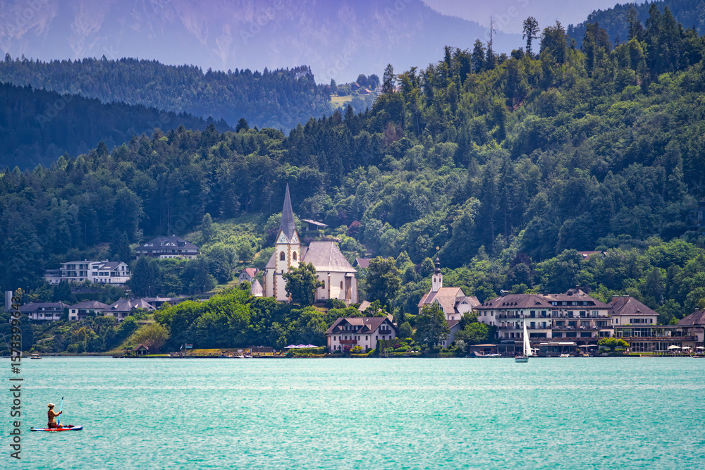 Fototapeta premium A view of the churches of Maria Wörth on Lake Wöhrtersee in Austria.
