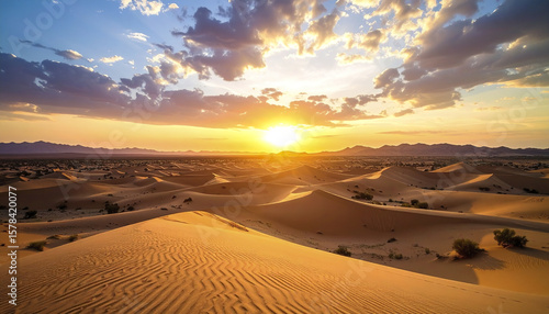 Fototapeta Naklejka Na Ścianę i Meble -  Sunset over sand dunes in desert with dramatic clouds and warm light