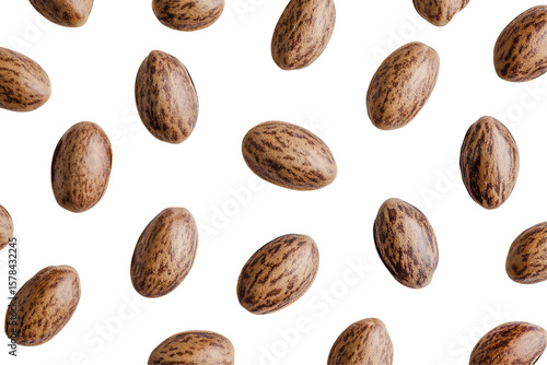 Castor beans scattered on a black background.