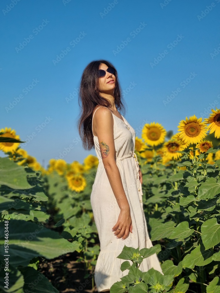 Obraz premium young woman in a field of sunflowers
