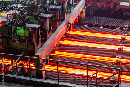 Schilderij op canvas Red hot steel bars on the conveyor belt during the production process in a steel