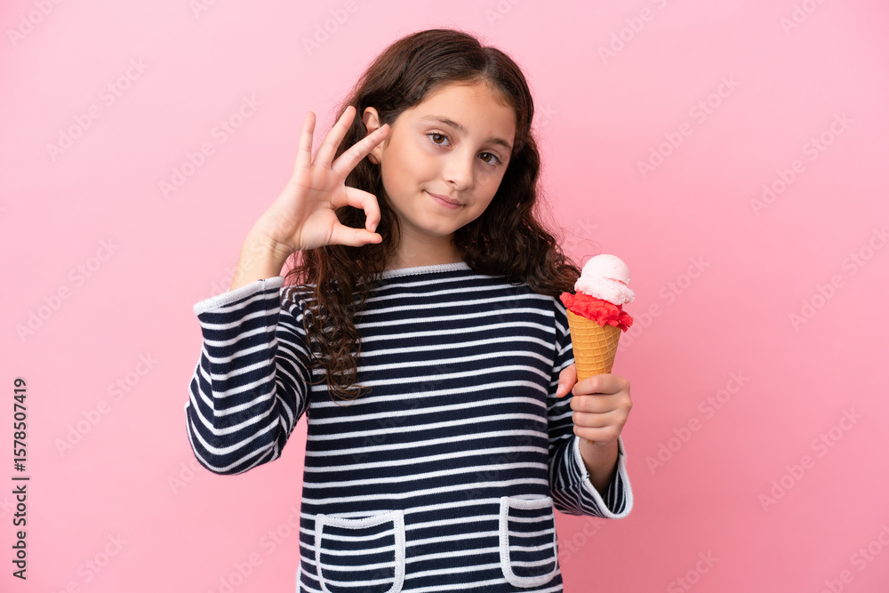 Little caucasian girl holding an ice cream isolated on pink background showing ok sign with fingers Little caucasian girl holding an ice cream isolated on pink background showing ok sign with fingers