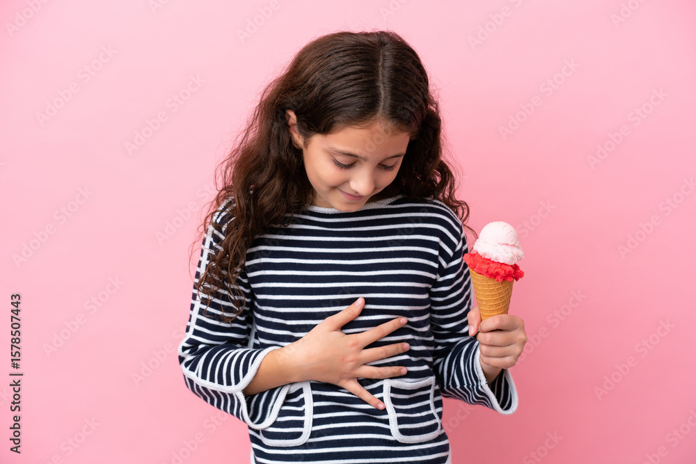 Little caucasian girl holding an ice cream isolated on pink background smiling a lot Little caucasian girl holding an ice cream isolated on pink background smiling a lot