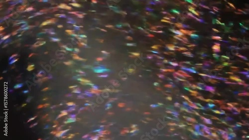 Abstract Colorful Sparkling Glitter Particles Moving Against a Dark Background