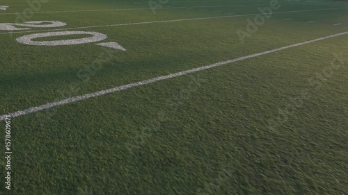High angle view American football field, showcasing the yard lines and green turf. Perfect for sports, game, background, and advertising.