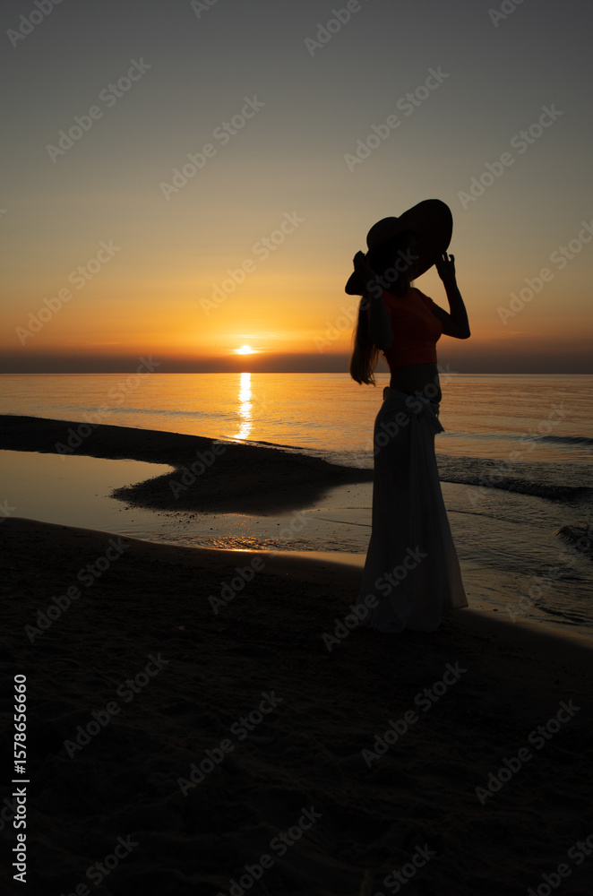 Fototapeta premium silhouette of a girl at sunset over the Baltic Sea